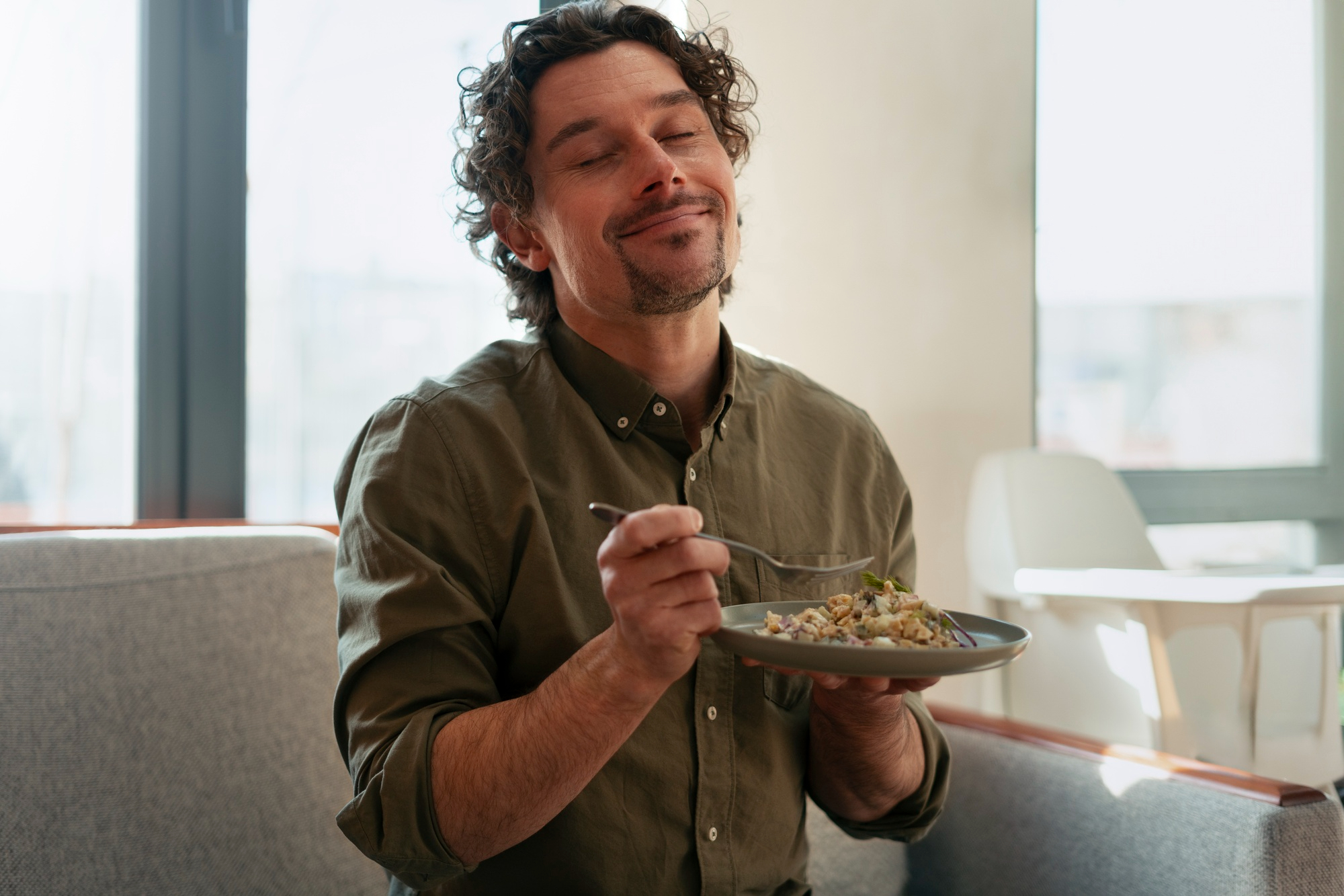 Hombre preparando alimentos frescos en una cocina luminosa